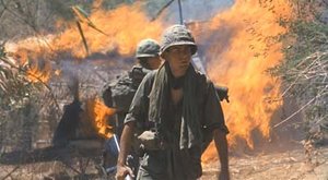 A scene from Platoon.  Taylor walks away from the village his platoon has set on fire.